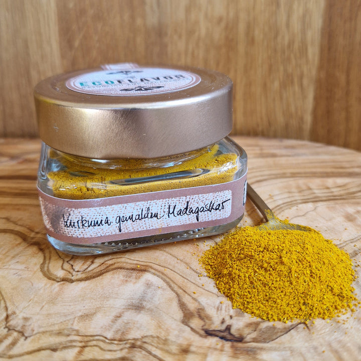 Leuchtend gelbes Kurkumapulver aus Madagaskar – fein gemahlen, naturbelassen und in einem Glas mit kupferfarbenen Deckel stilvoll angerichtet.